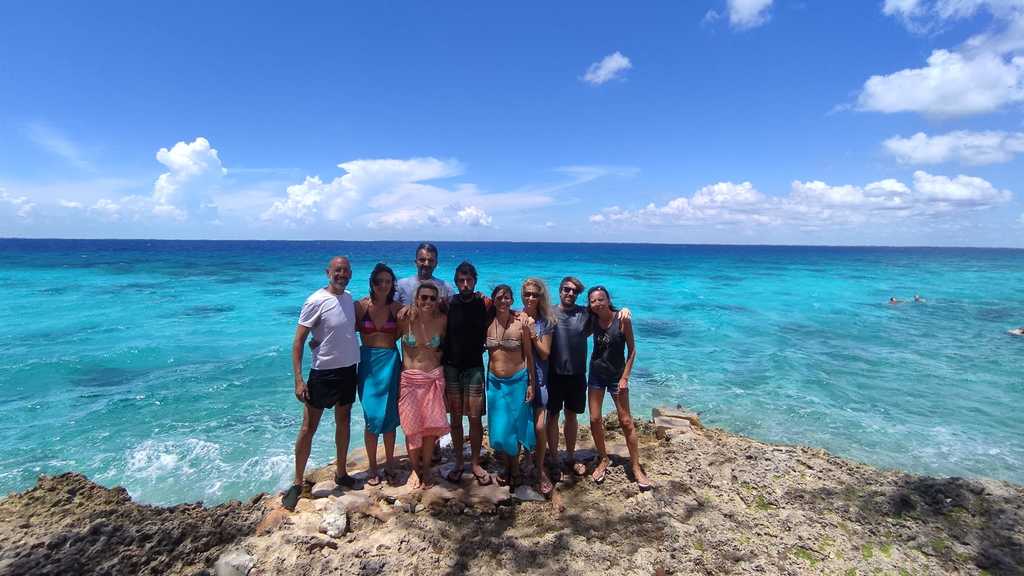 A group of people in front of the beauty of the Caribbean sea 
