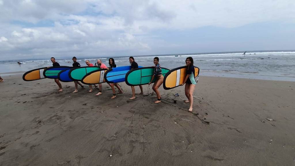 A group of people ready to do some surf 