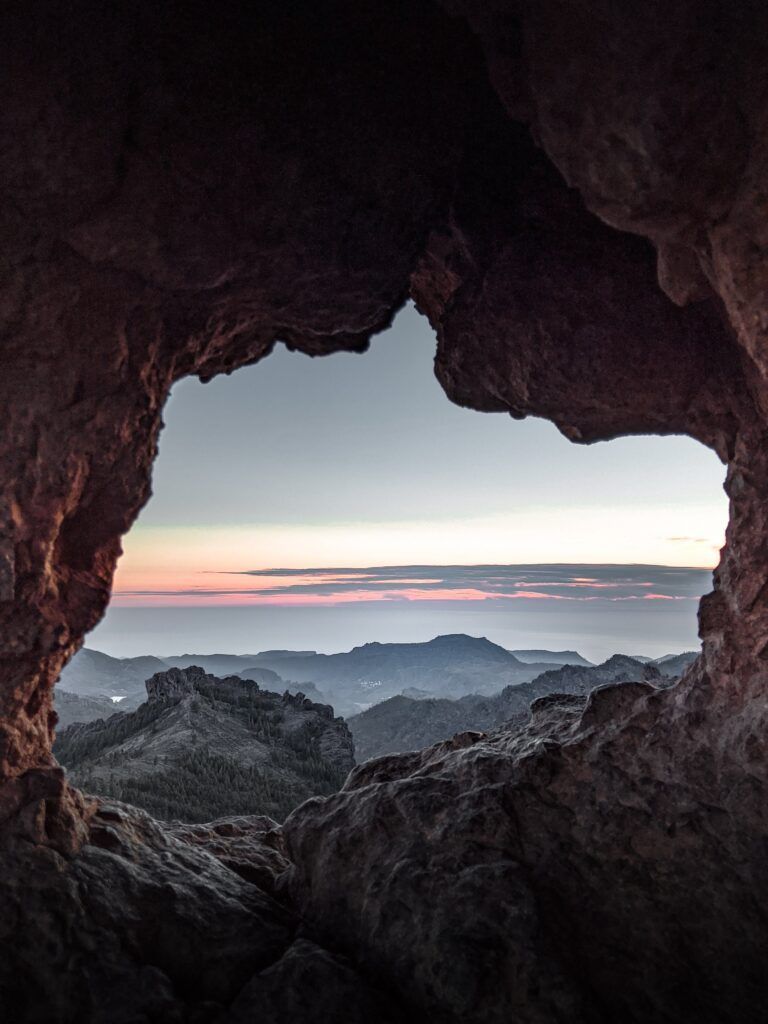 From the rocks of Roque Nublo you can glimpse the mountains of Grand Canaria