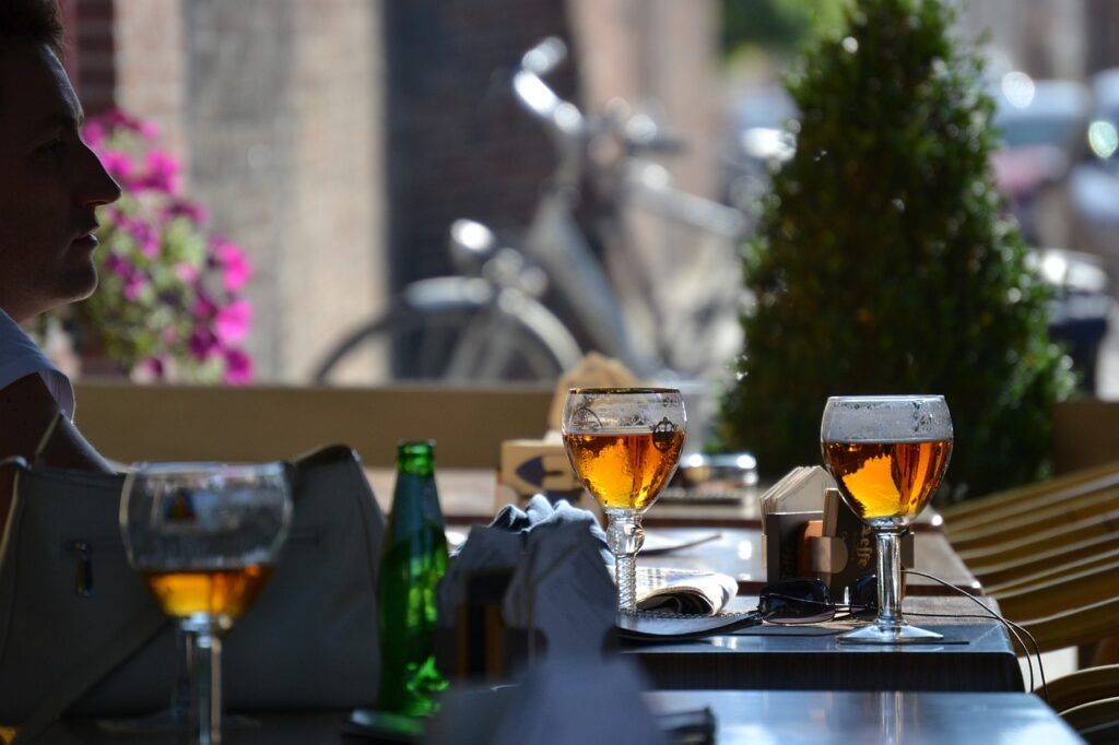 A table with three glasses of Belgian beer in the foreground