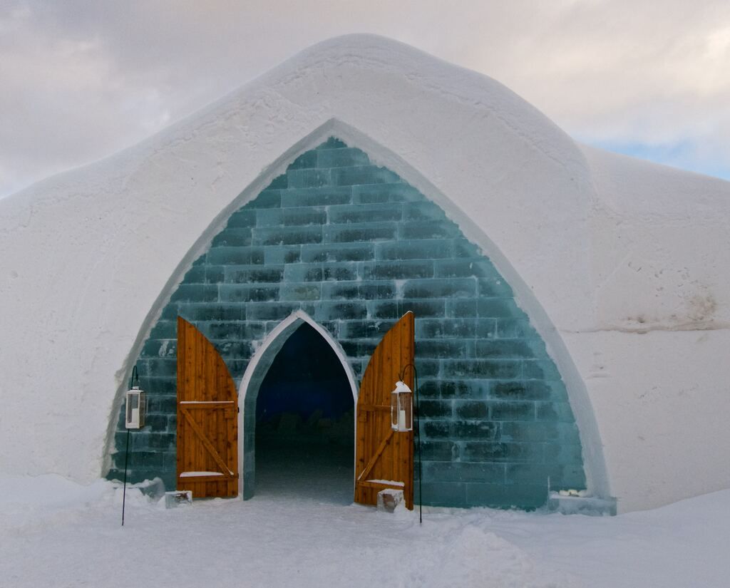 Photograph of a brown wooden door leading into an open igloo