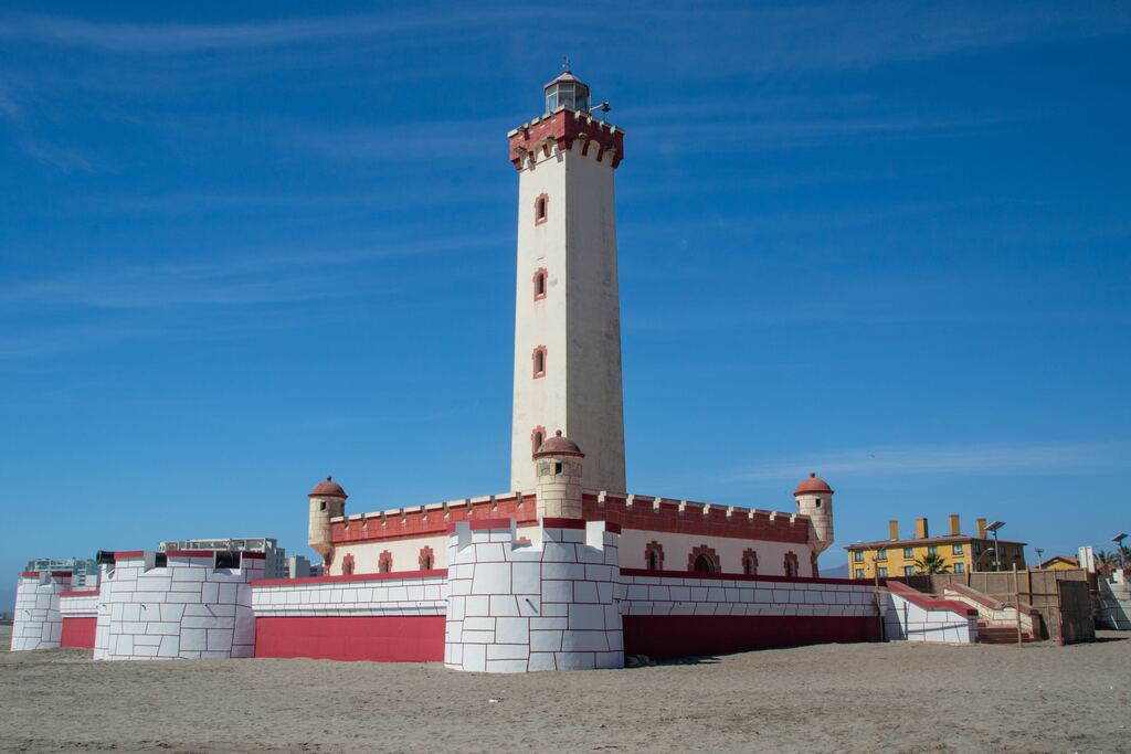 Brown and white concrete lighthouse under blue sky during the daytime