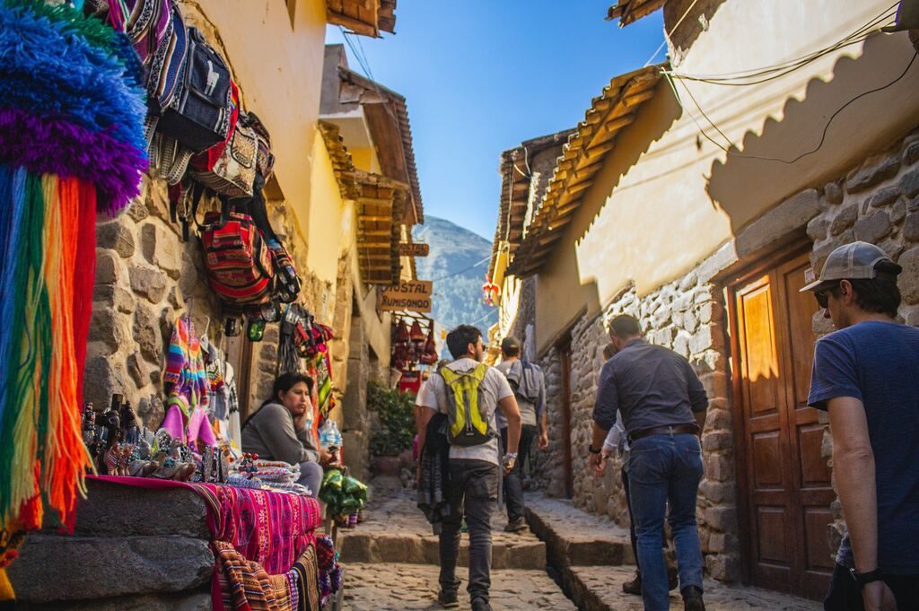people walking through the colourful streets of Cusco during the day