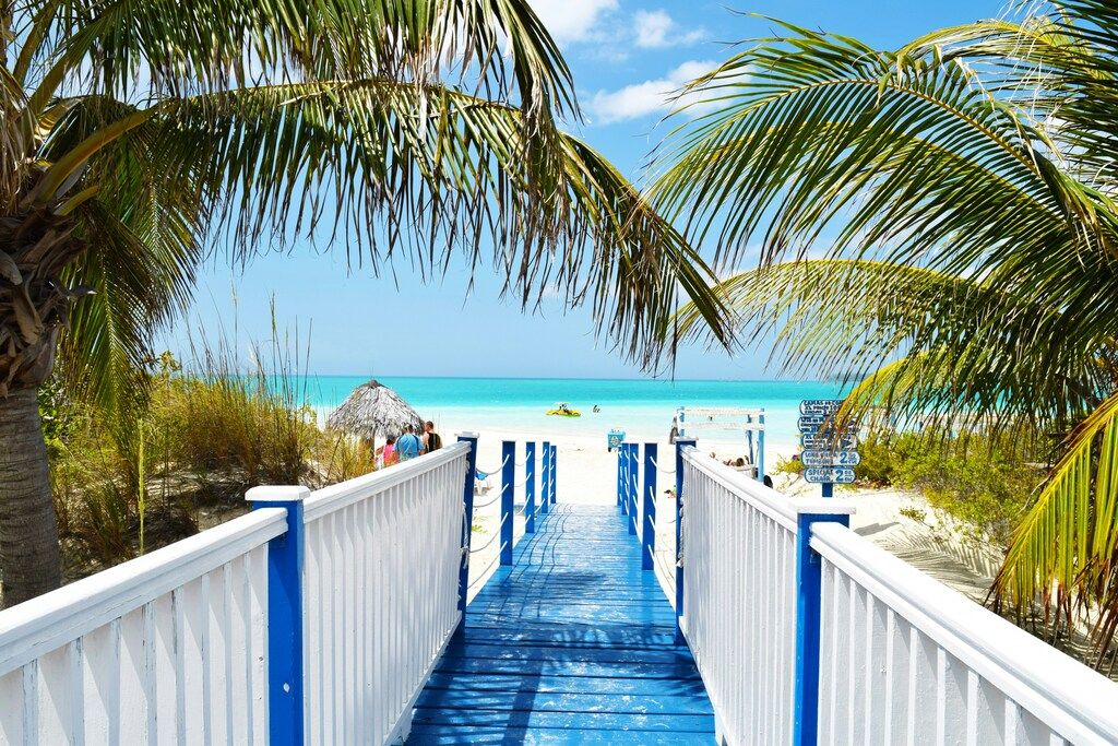 Blue and white wooden bridge by the ocean.
