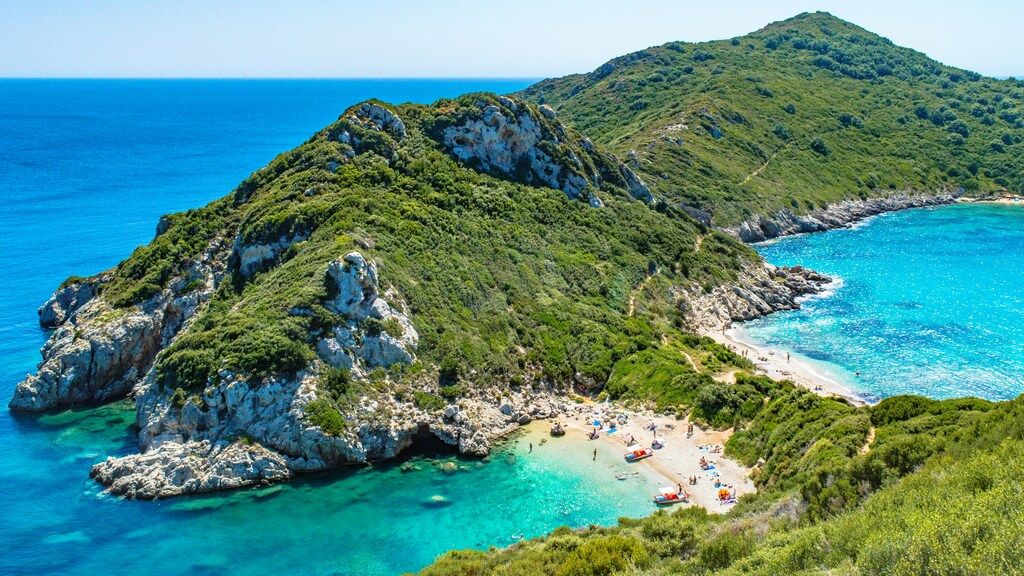 A picturesque view of Porto Timoni beach on Corfu, with two beautiful coves and turquoise waters surrounded by lush green hills