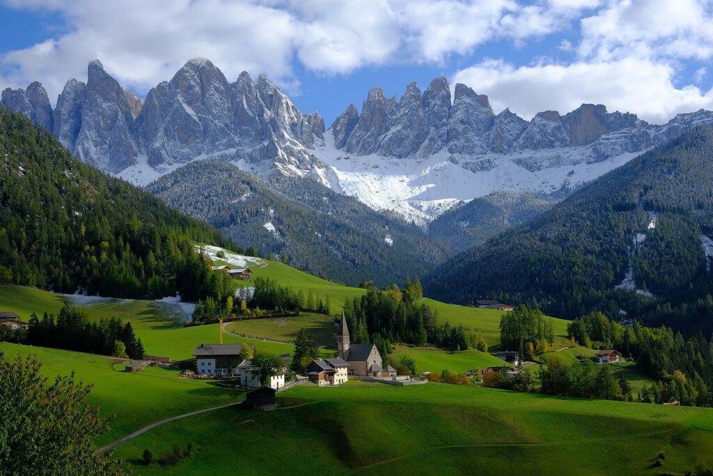 Picturesque village in the Dolomites with snowy mountains, Italy