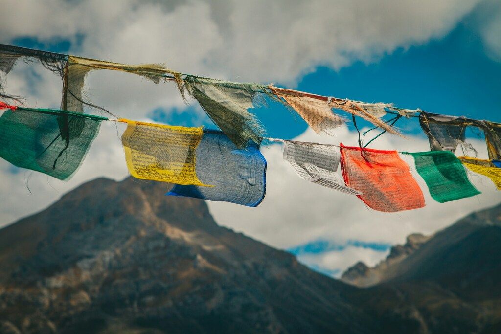 Colorful prayer flags fluttering in front of a mountain in Nepal