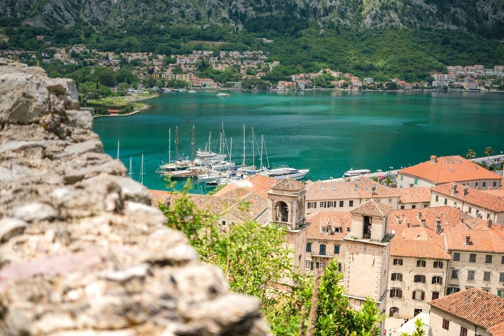 Scenic view of Kotor Bay in Montenegro with yachts and red-roofed buildings.