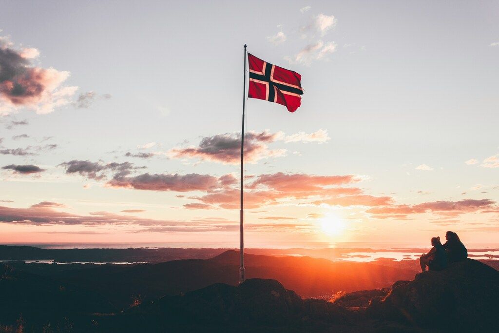 Norwegian flag at sunset with people enjoying the view, Norway
