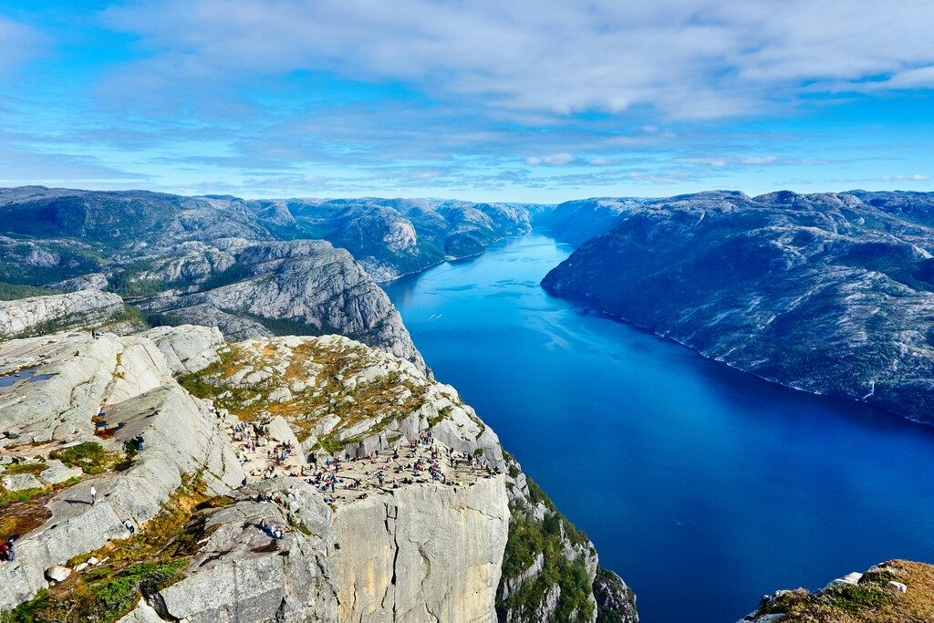 Panoramic view of the majestic Preikestolen (Pulpit Rock) overlooking the blue waters of the Lysefjord in Norway