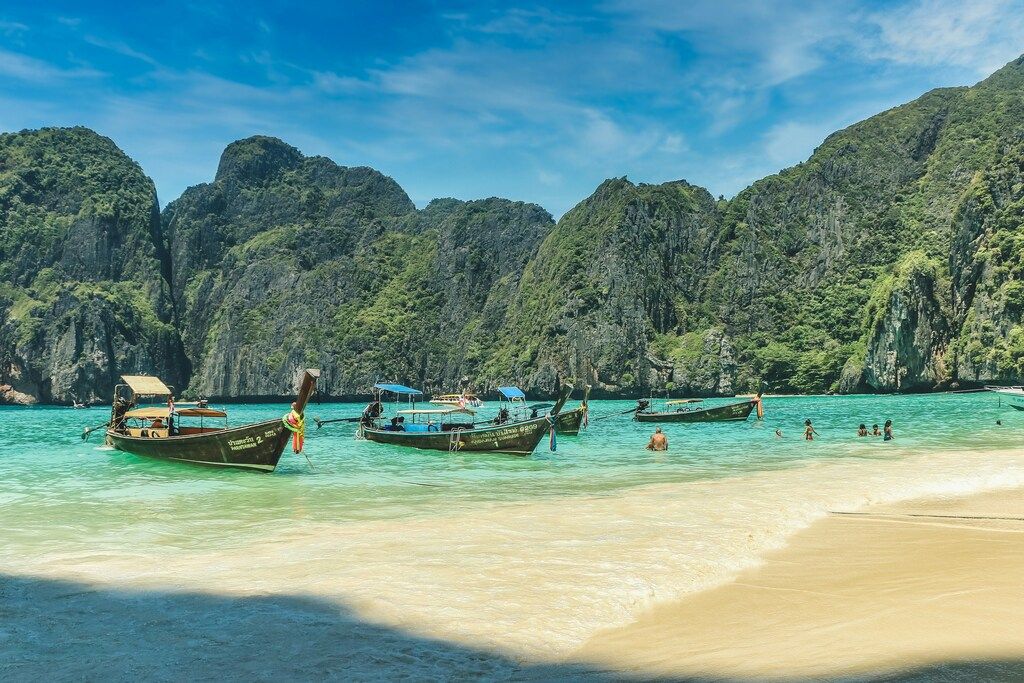 Traditional Thai long-tail boats floating in the turquoise waters of a scenic beach in Thailand