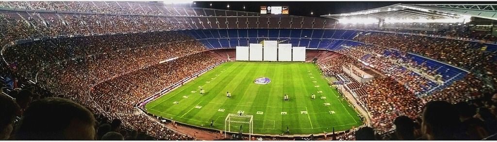 Panoramic view of Camp Nou stadium during a lively football match.