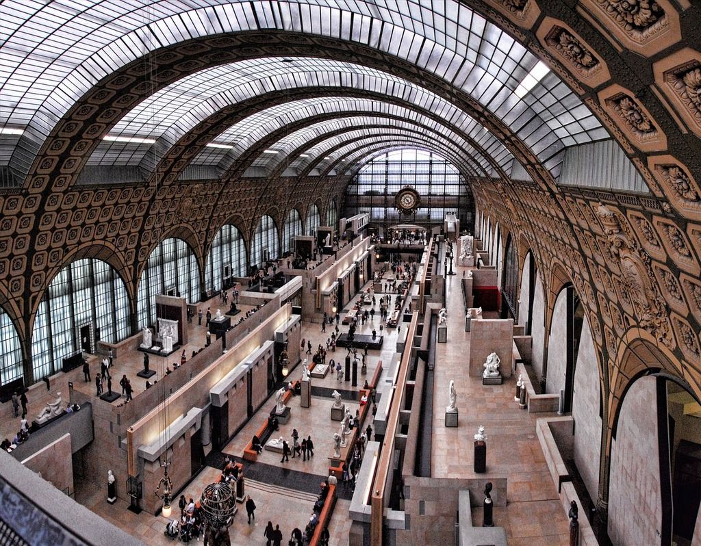 The interior of the Musée d'Orsay in Paris, showcasing its grand arches, ornate ceiling, and art exhibitions