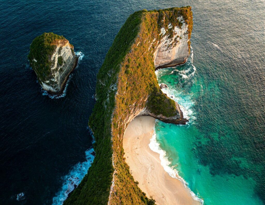 Aerial view of Kelingking Beach on Nusa Penida Island, Indonesia, with turquoise water and cliffs.