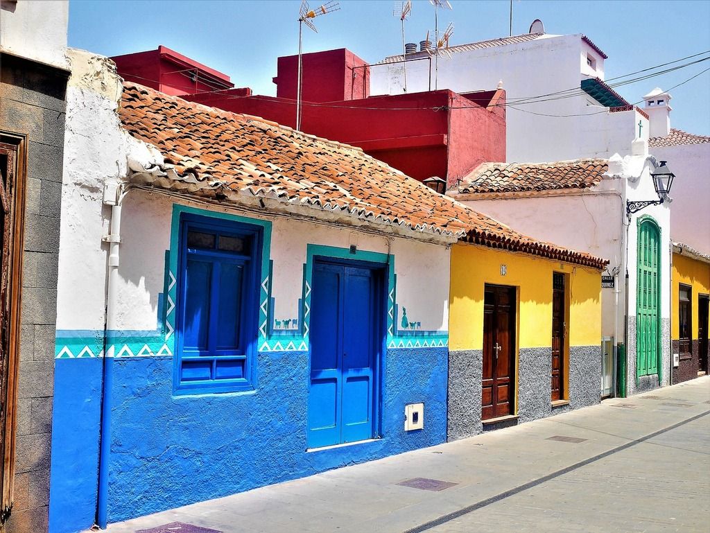 Colorful traditional houses with bright blue and yellow facades in La Orotava, Tenerife.