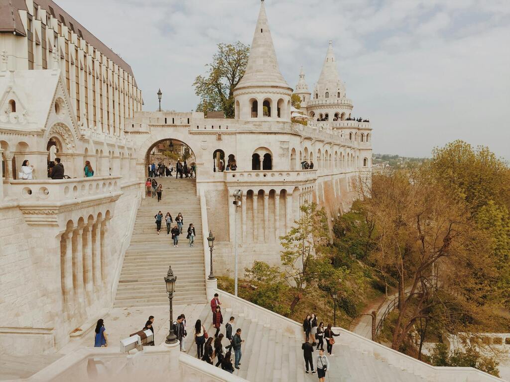 Fisherman's Bastion in Budapest, Hungary, with tourists exploring the historic architecture.
