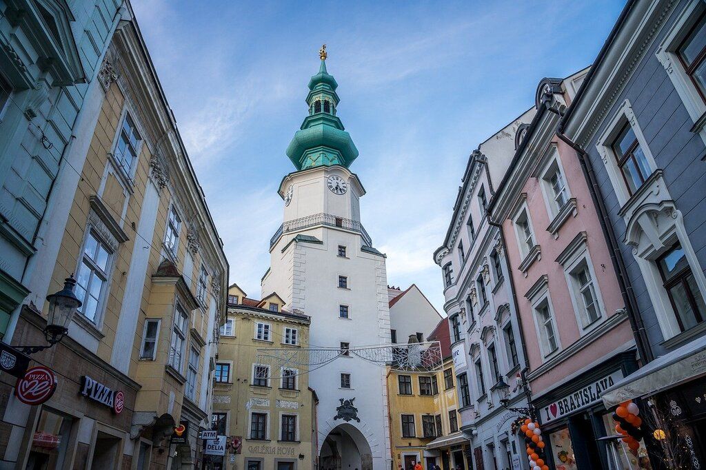 Michael's Gate, a famous medieval tower in Bratislava's old town, surrounded by colorful buildings and cobblestone streets.