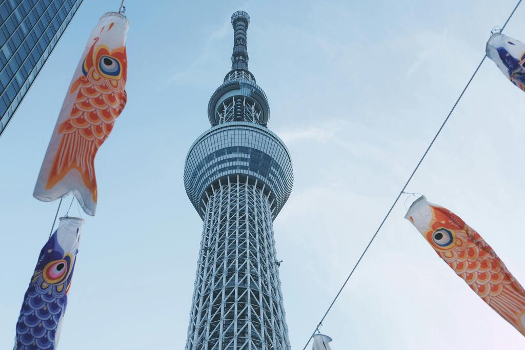 Tokyo Skytree surrounded by colorful koi fish streamers, celebrating a traditional Japanese festival.