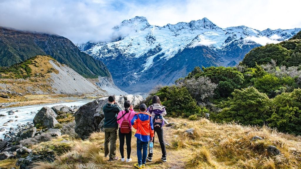 Travelers exploring Mount Cook National Park, admiring snow-capped mountains and stunning natural landscapes