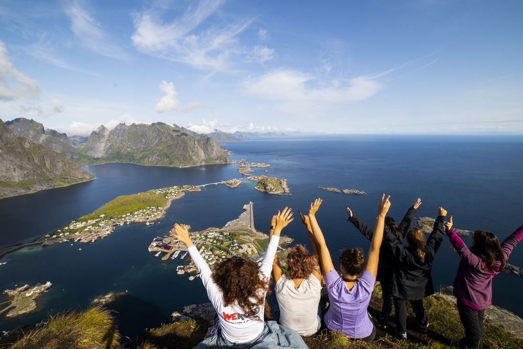 Group of travelers enjoying a panoramic view of the Lofoten Islands in Norway, part of a WeRoad group trip.