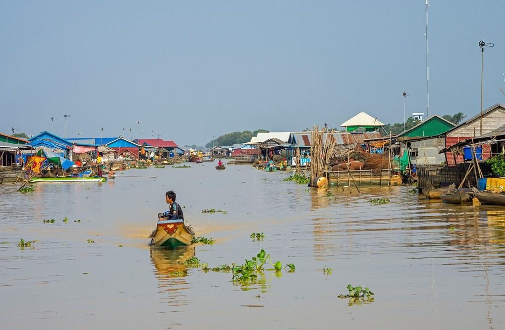 Floating village on the Tonlé Sap Lake in Cambodia, with traditional wooden houses and boats on the water.
