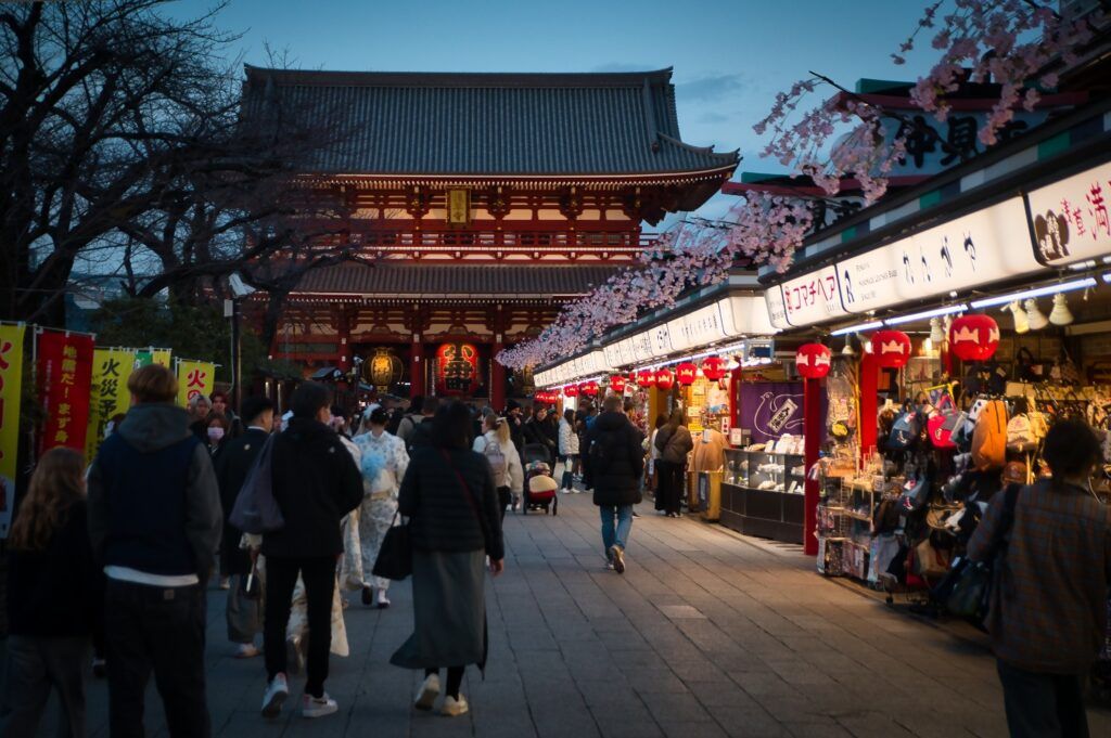 Nakamise-dori street leading to a large red temple in Asakusa, lined with shops.